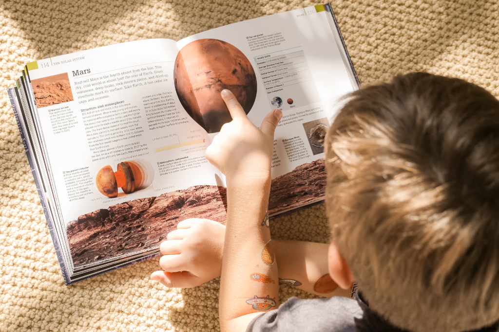 child reading living book about space