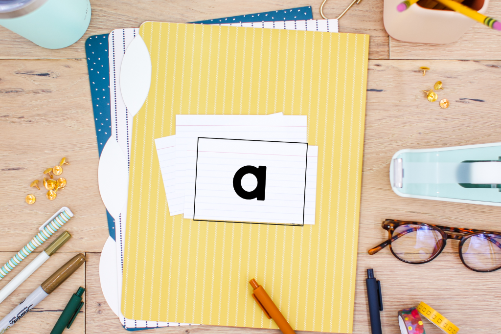 File folders and an index card with a single letter used for organizing a letter and sound assessment in a homeschool setting.