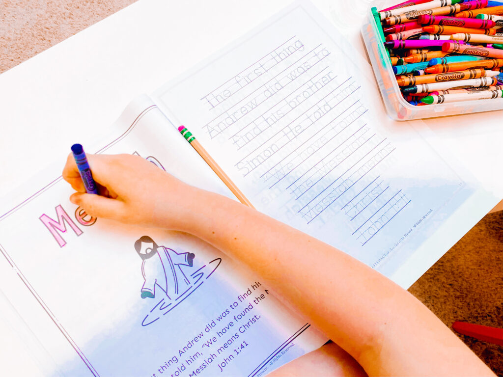 Child doing Bible verse copywork at homeschool table