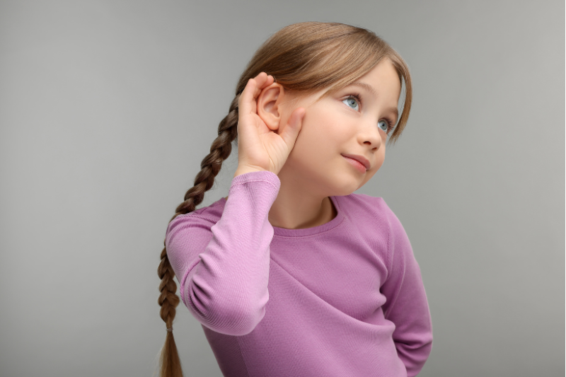 Child listening closely as part of a phonemic awareness activity for teaching rhyming words at home.